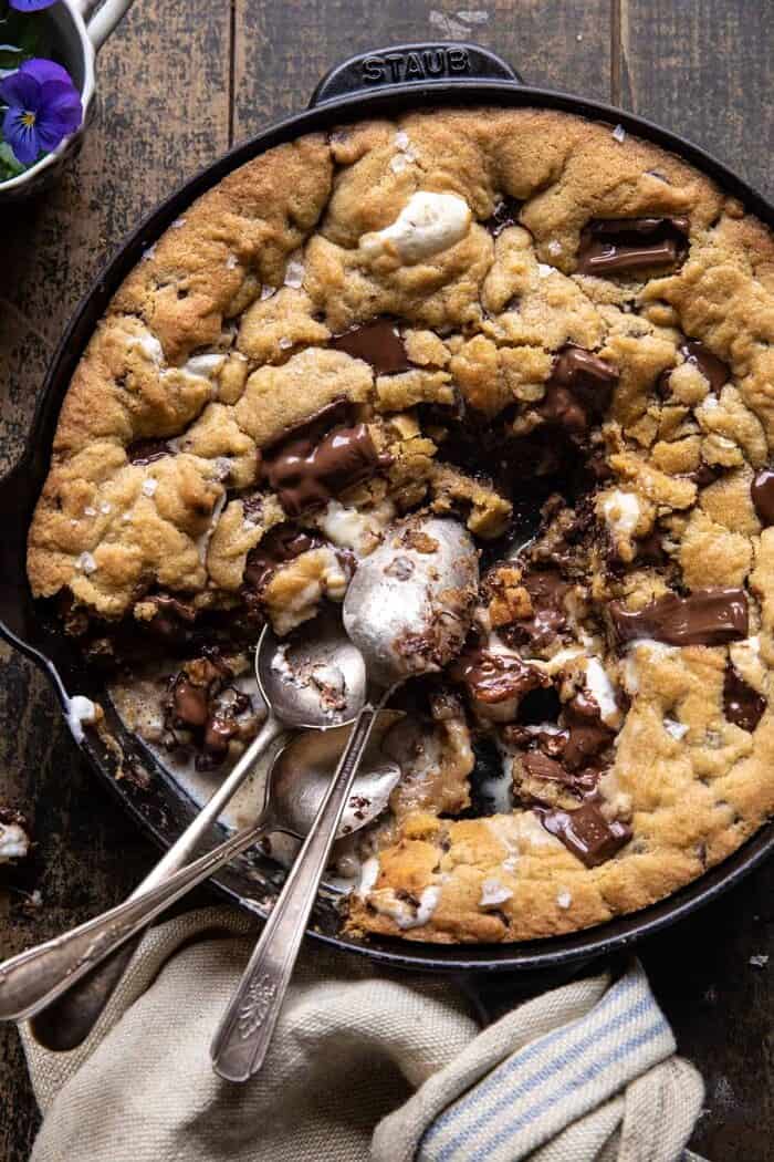 Giant S’mores Stuffed Chocolate Chip Skillet Cookie | halfbakedharvest.com overhead photo of Giant S’mores Stuffed Chocolate Chip Skillet Cookie with spoons in skillet