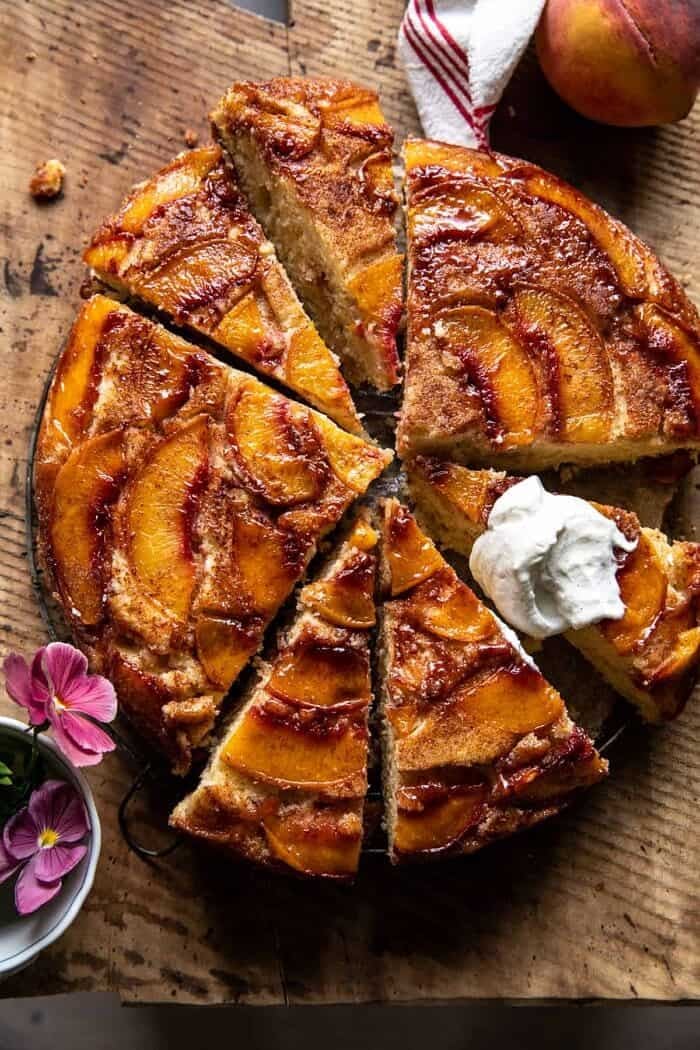 Skillet Cinnamon Sugar Peach Upside Down Cake | halfbakedharvest.com overhead photo of Skillet Cinnamon Sugar Peach Upside Down Cake with whipped cream on top