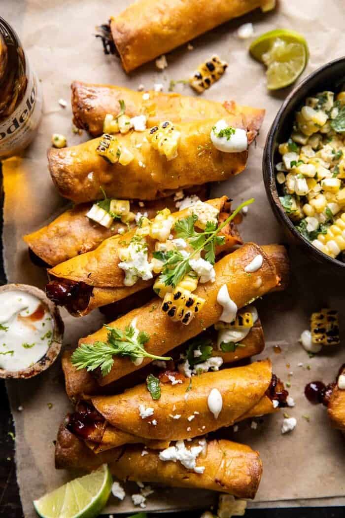 overhead close up photo of Crockpot BBQ Beer Chicken Taquitos with Street Corn Salsa | halfbakedharvest.com