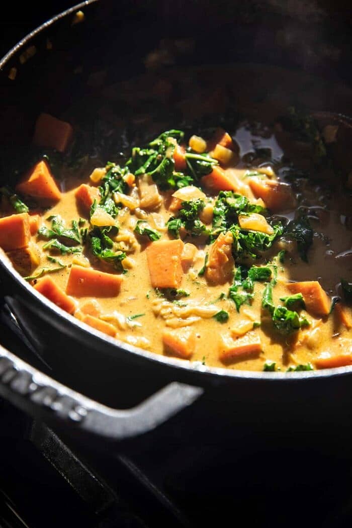 side angle prep photo of Gingery Coconut Sweet Potato and Rice Stew cooking on the stove