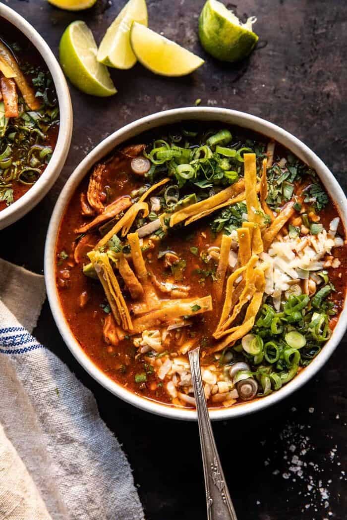 overhead photo of Slow Cooker Chipotle Chicken Tortilla Soup with Salty Lime Chips with spoon in bowl 