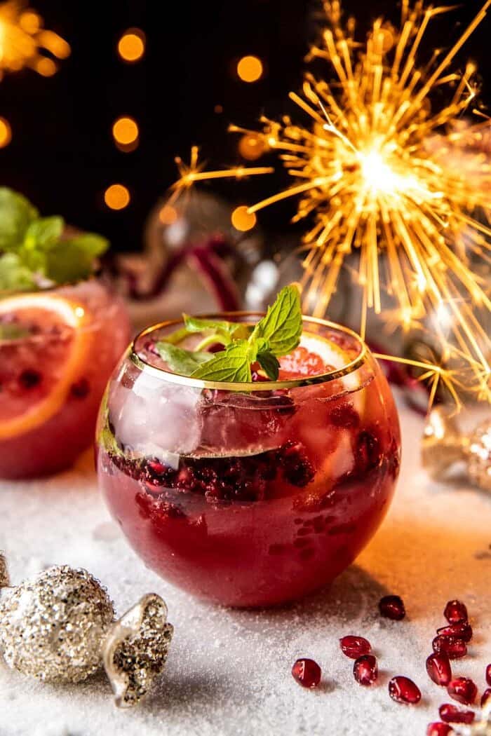 Citrus Pomegranate Champagne Twist | halfbakedharvest.com front on photo of Citrus Pomegranate Champagne Twist with sparklers in the background