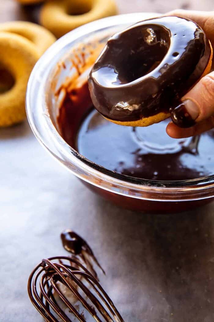 Baked Hot Chocolate Doughnuts | halfbakedharvest.com prep photo of dipping doughnuts in glaze