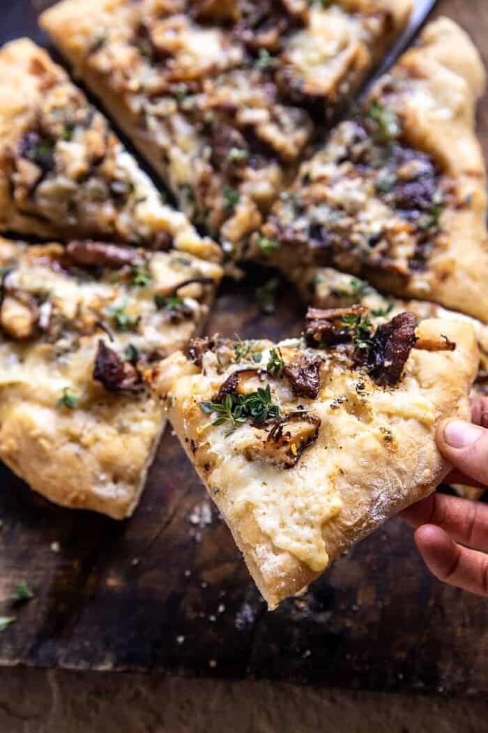 Balsamic Mushroom Fontina Pizza | halfbakedharvest.com pizza slice with bite taken out