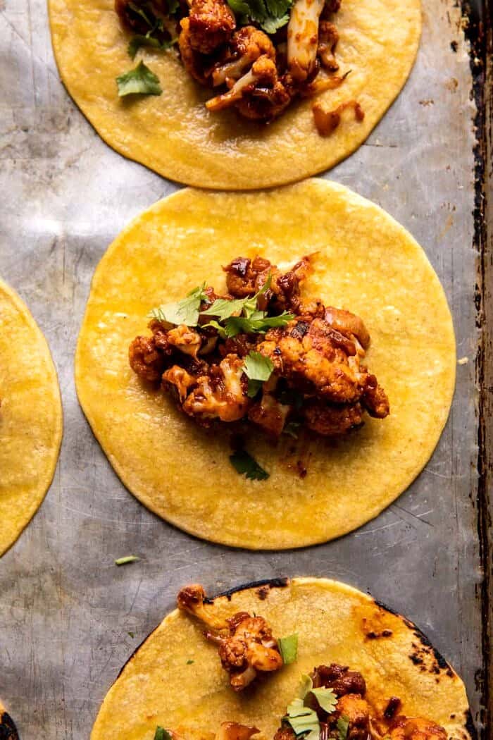 Crispy Cauliflower Tinga Tacos with Honey Lime Avocado Crema | halfbakedharvest.com prep photo of Crispy Cauliflower Tinga tacos being assembled