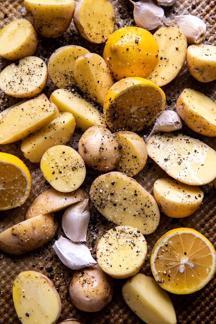 Sheet Pan Roasted Lemon Garlic Butter Salmon with Feta and Olives | halfbakedharvest.com prep photo of potatoes on baking sheet