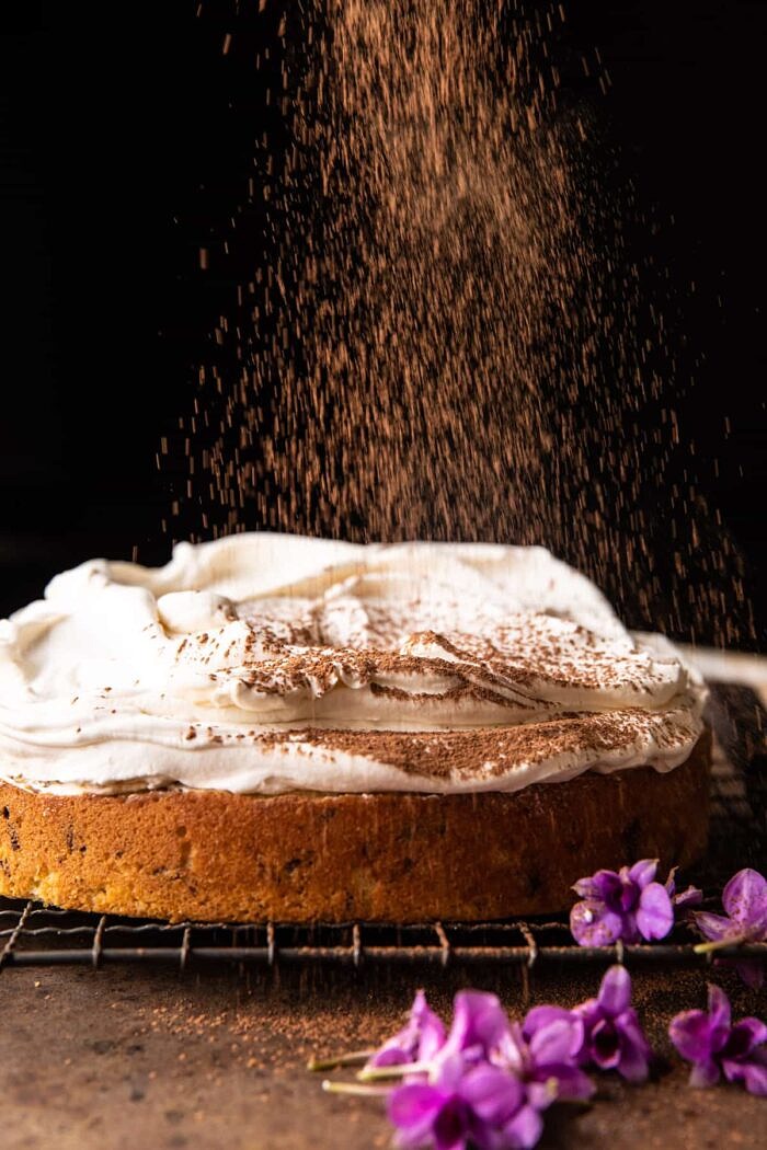 process photo of Vanilla Tiramisu Cake being dusted with cocoa