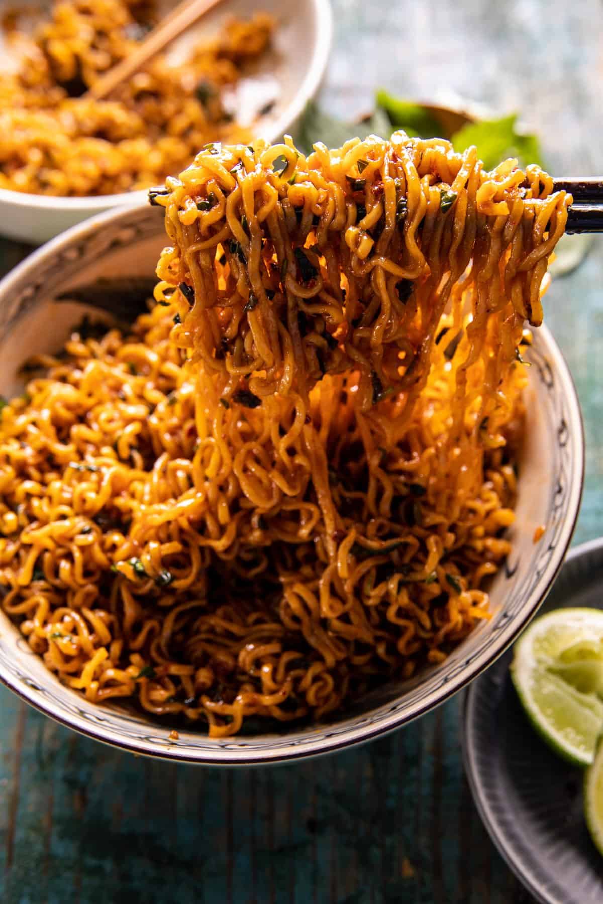 noodles in a bowl being picked up with chopsticks 