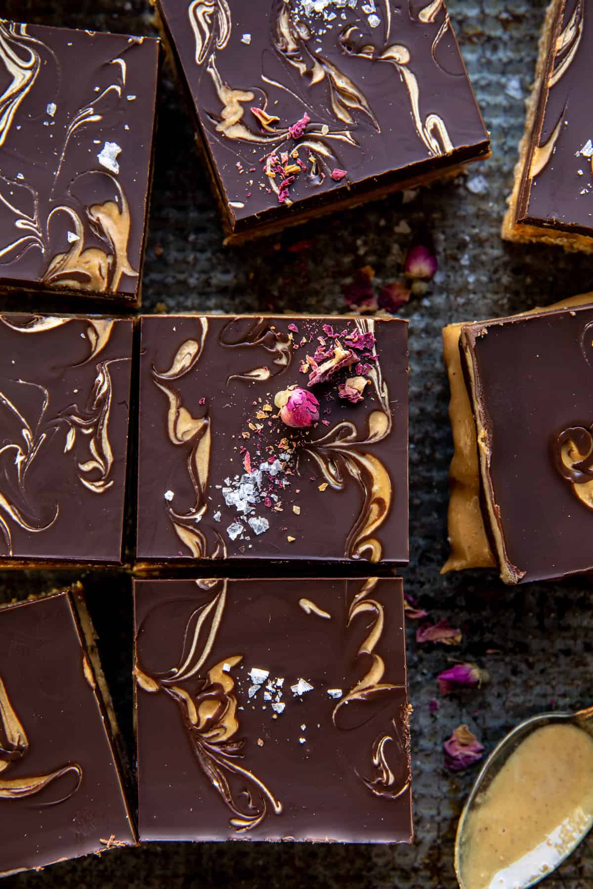 close up photo of peanut bars with spoon of peanut butter