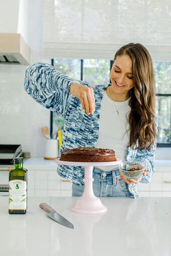 tieghan sprinkling chocolate on cake